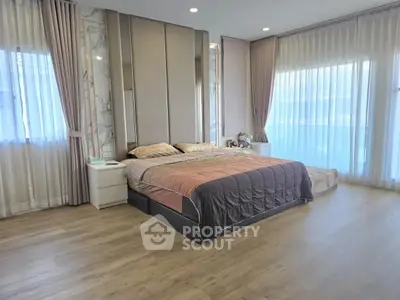 Spacious modern bedroom with elegant decor and large windows for natural light.