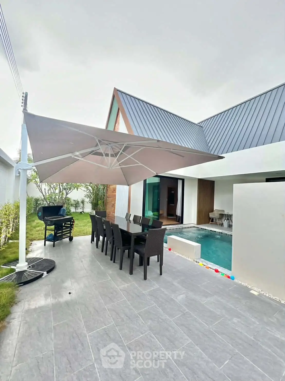 Modern outdoor patio with pool and dining area, perfect for entertaining.