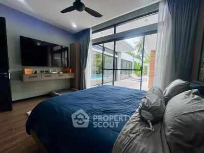 Luxurious bedroom with pool view, modern decor, and large TV, perfect for relaxation and comfort.