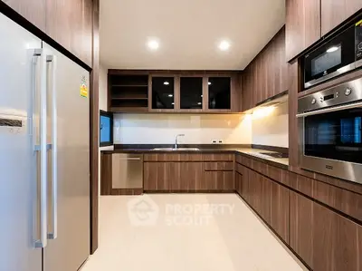 Modern kitchen with sleek wooden cabinetry and stainless steel appliances