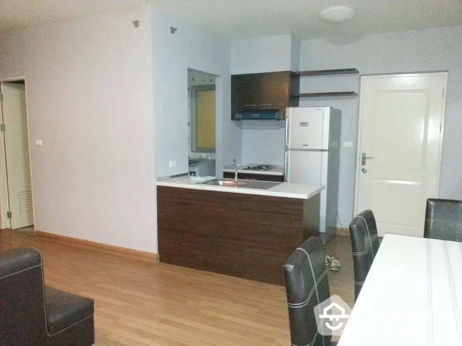 Modern kitchen with dining area featuring sleek cabinetry and hardwood flooring