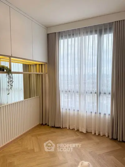 Elegant corner unit with floor-to-ceiling windows and stylish parquet flooring, offering a bright and airy ambiance.