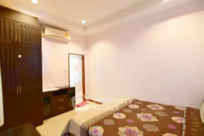 Cozy bedroom with built-in wardrobe and air conditioning in modern apartment.