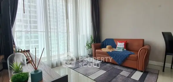 Modern living room with large windows and stylish decor in a high-rise apartment.