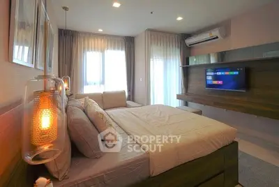 Modern bedroom with stylish decor, large windows, and wall-mounted TV in a cozy apartment.