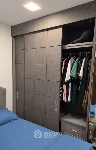 Modern bedroom with stylish wardrobe and cozy blue bedding