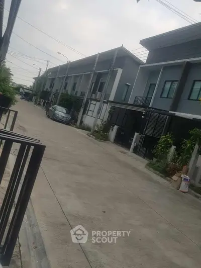 Modern townhouse complex with sleek design and spacious driveway in a serene neighborhood.