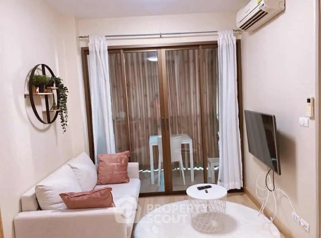 Cozy living room with modern decor and balcony access in a stylish apartment.