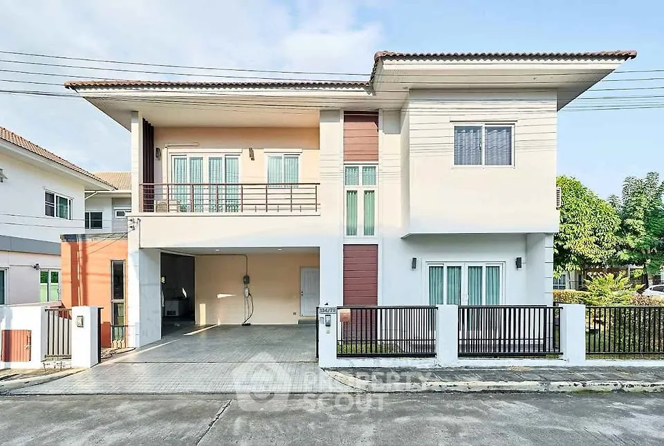 Modern two-story house with spacious driveway and balcony in suburban neighborhood.