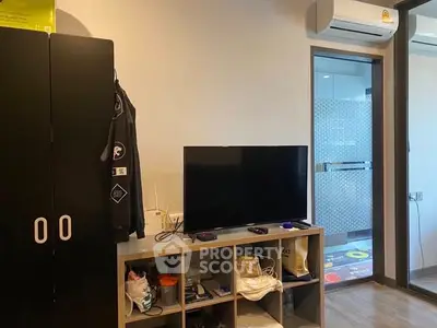 Modern living space with TV and air conditioning, featuring sleek storage solutions.