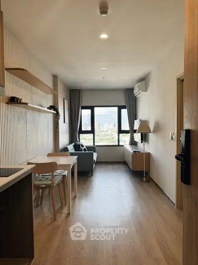 Modern living room with city view, featuring sleek furniture and wooden flooring.