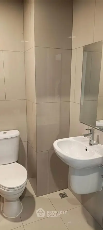 Modern bathroom with sleek fixtures and neutral tiles, perfect for a contemporary home.