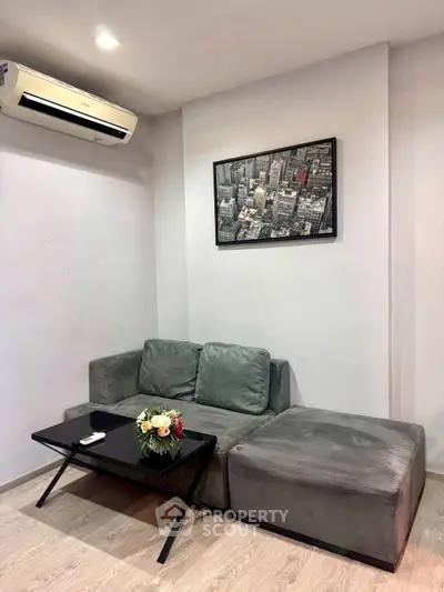 Cozy living room with modern gray sofa and stylish cityscape artwork, perfect for relaxation.