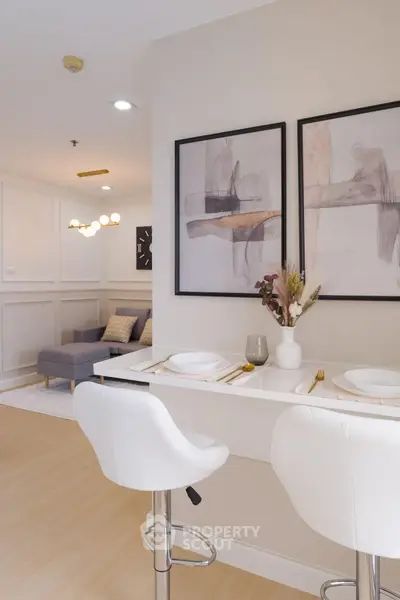 Modern living room with stylish decor and dining area, featuring elegant artwork and comfortable seating.