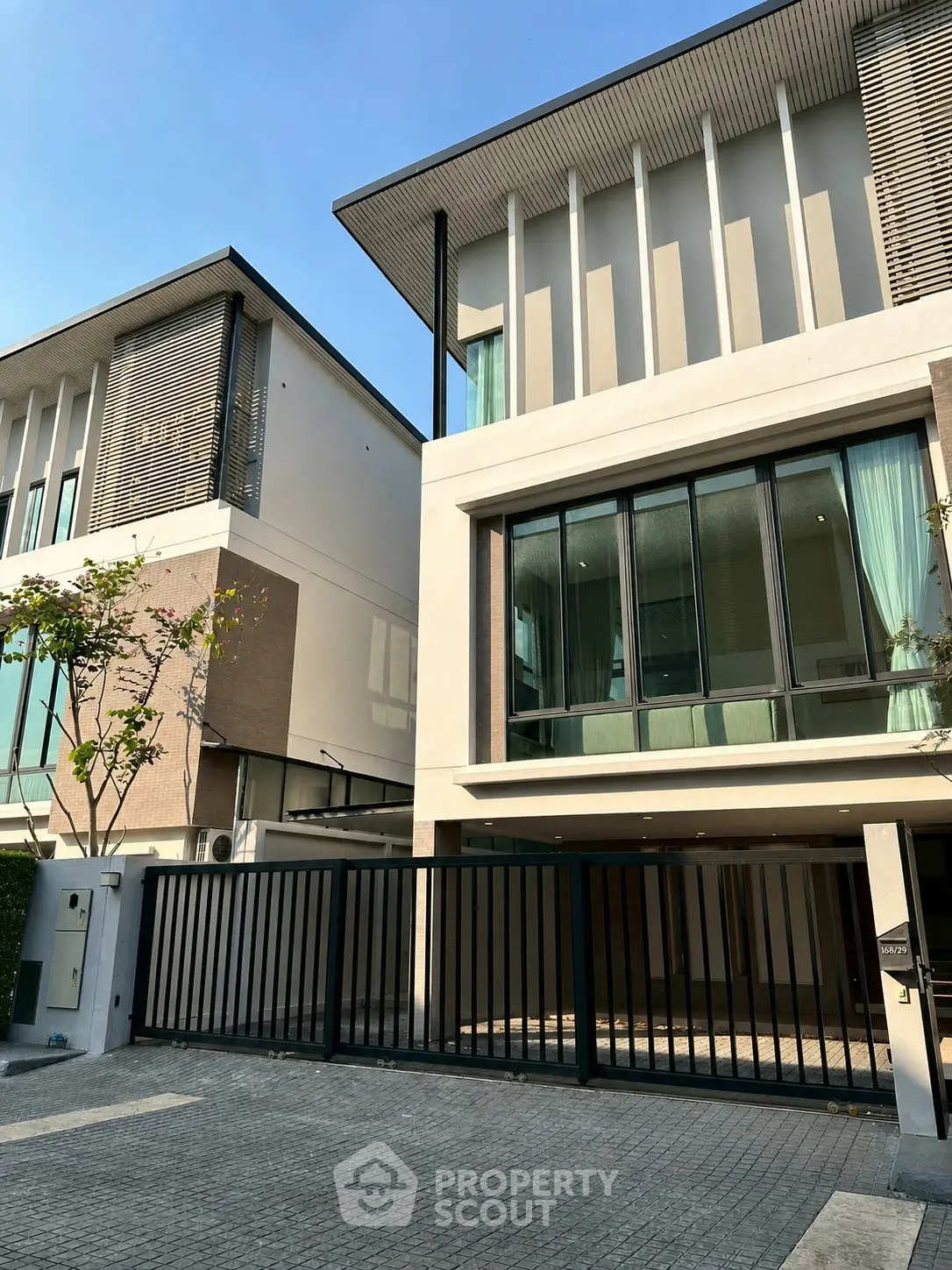 Modern luxury townhouse with large windows and sleek design in a desirable neighborhood.