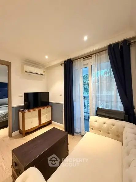 Charming living room with elegant decor and natural light, featuring a cozy sofa and modern entertainment setup.