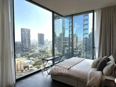 Luxurious bedroom with floor-to-ceiling windows offering stunning cityscape views.