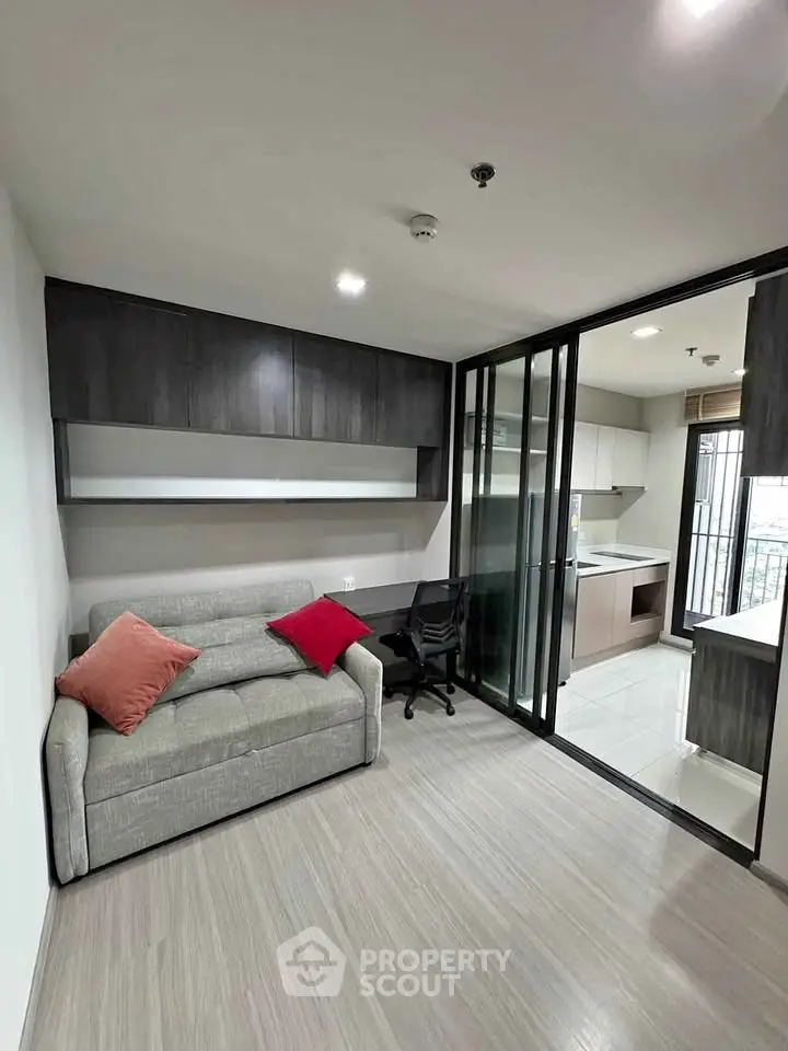 Modern living room with sleek design and open kitchen layout, featuring stylish furniture and ample natural light.