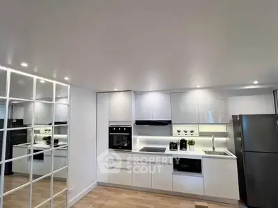 Modern kitchen with sleek white cabinets and built-in appliances, perfect for contemporary living.