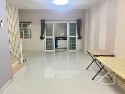 Spacious living room with modern design and ample natural light, featuring sleek tiled flooring and stylish decor.
