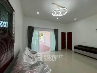 Spacious modern living room with stylish lighting and large windows for natural light.