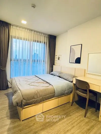 Modern bedroom with stylish decor and large window offering city views.