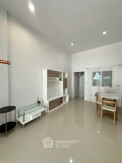 Spacious modern living room with sleek furniture and glossy tiled floors, perfect for comfortable living.