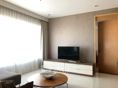 Modern living room with sleek TV stand and large window, offering a bright and inviting atmosphere.