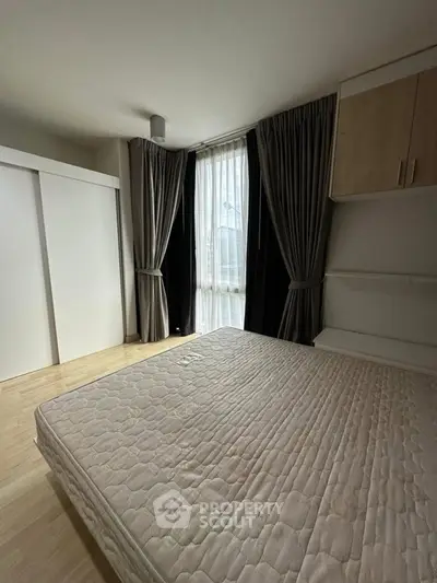 Spacious bedroom with large window and modern furnishings