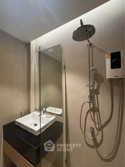 Modern bathroom with sleek shower and stylish sink in contemporary apartment.