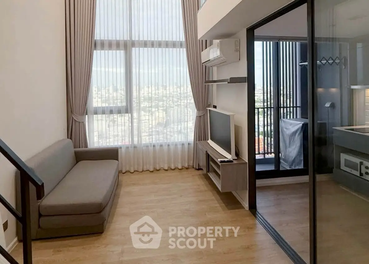 Modern living room with city view and balcony access in high-rise apartment