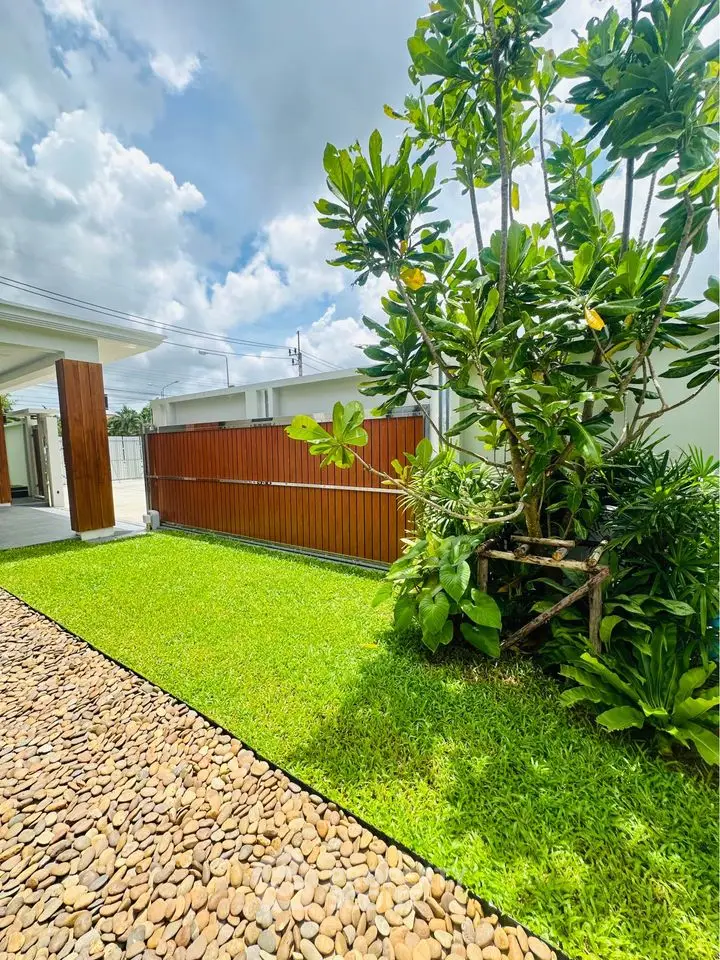 Beautiful garden with lush greenery and stone pathway in modern residential property.