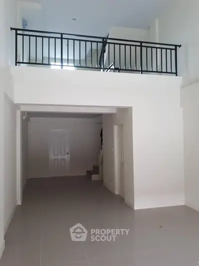 Spacious modern interior with high ceilings and mezzanine level, perfect for stylish living.