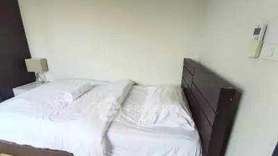 Cozy bedroom with neatly made bed and modern decor, perfect for relaxation.