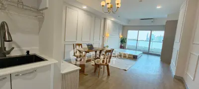 Spacious modern living room with city view, featuring elegant decor and ample natural light.