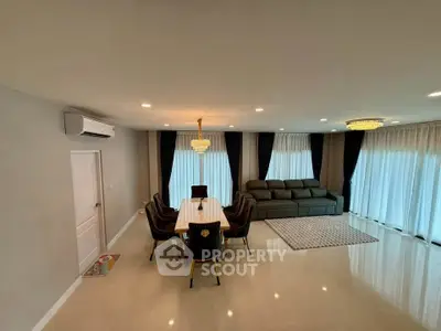 Spacious modern living room with elegant dining area and luxurious chandelier