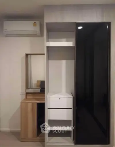 Modern bedroom with sleek wardrobe and air conditioning unit, perfect for urban living.