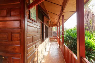 Charming wooden balcony with lush greenery and warm sunlight
