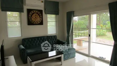 Charming living room with plush sofa and garden view, perfect for relaxation and entertaining.