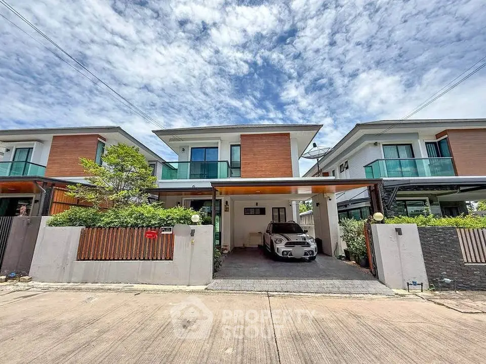 Modern two-story house with carport and stylish facade in a suburban neighborhood.