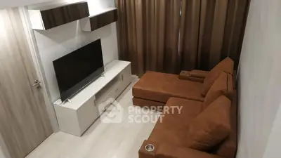 Cozy living room with modern brown sofa and flat-screen TV, perfect for relaxation.