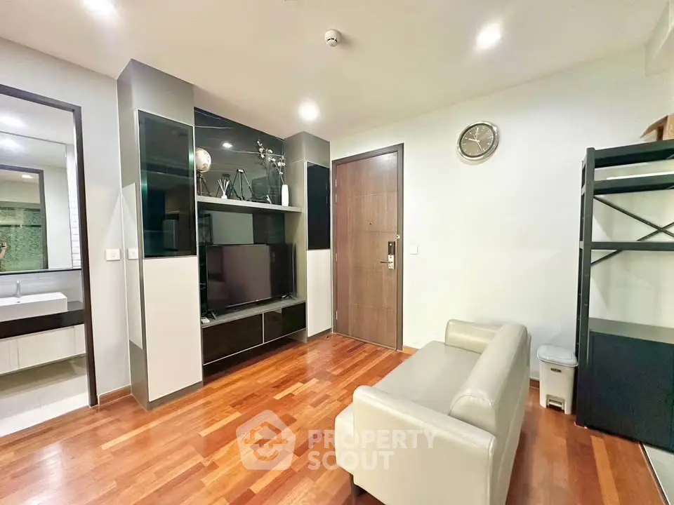 Modern living room with sleek design, wooden flooring, and stylish shelving unit.