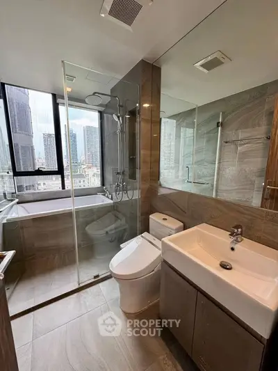 Modern bathroom with city view, glass shower, and sleek fixtures in luxury apartment.