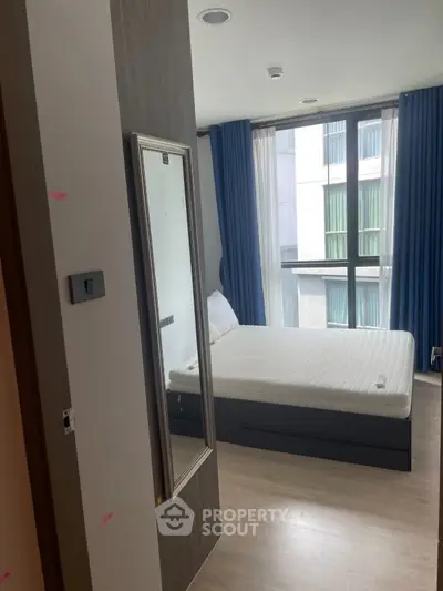 Modern bedroom with large window and stylish decor in urban apartment