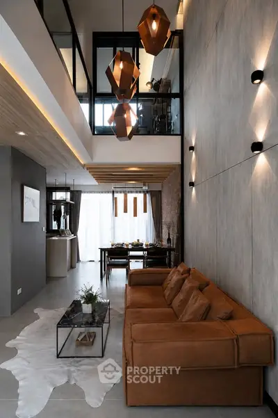 Modern living room with high ceiling, stylish lighting, and elegant decor in a luxury apartment.