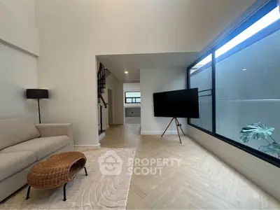 Spacious modern living room with large window and stylish decor