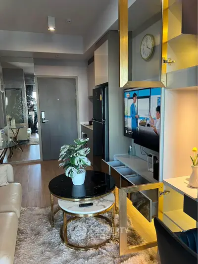 Modern living room with stylish decor and open layout, featuring a cozy seating area and sleek TV setup.