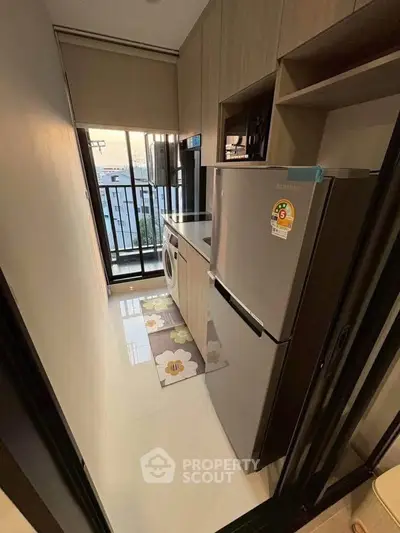 Compact kitchen with modern appliances and balcony view in urban apartment