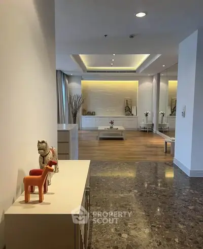 Spacious modern living room with elegant decor and marble flooring, featuring recessed lighting and a stylish open layout.