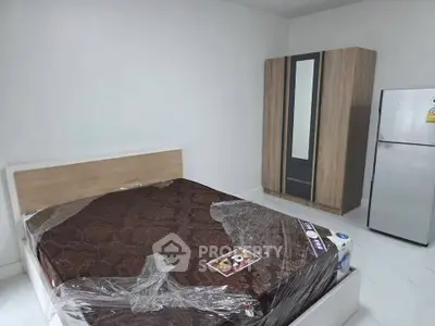 Modern bedroom with sleek wardrobe and stainless steel fridge